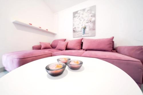 two bowls on a table in a living room with a couch at Sea View Apartment + Pool, Ljubač, 32 m² in Ljubač