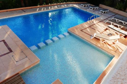 - une grande piscine avec 2 chaises longues dans l'établissement Maison avec vue mer à Sainte-Maxime, piscine partagée, à Sainte-Maxime