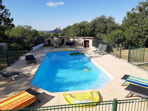 a large swimming pool with chairs and a pool noodle in a yard at Villa élégante à Méjannes-lès-Alès avec piscine privée in Méjannes-lès-Alès