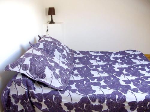 Thil-sur-Arroux的住宿－Maison de 4 chambres avec vue sur le lac et jardin clos a Thil sur Arroux，一张带紫色和白色棉被及枕头的床