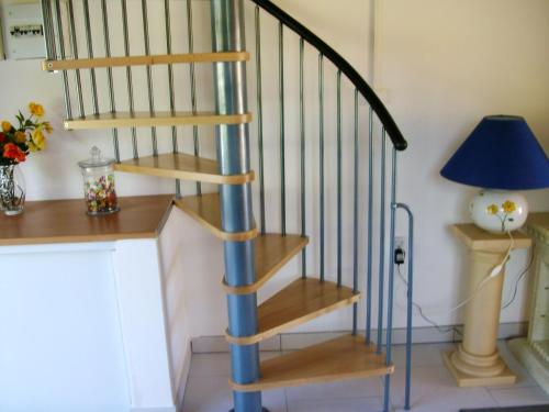 a wooden spiral staircase in a room with a lamp at Maison charmante avec vue sur lac à Thil-sur-Arroux in Thil-sur-Arroux