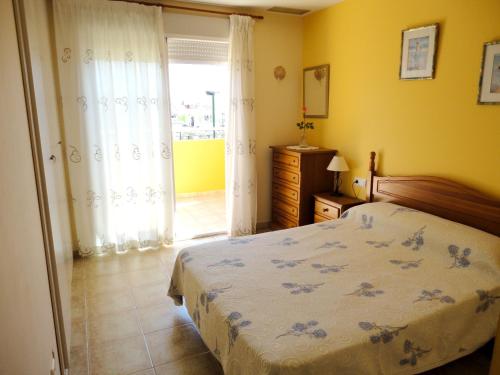 a bedroom with a bed and a room with a window at Comfortable Apartment in Dénia + Pool in Denia