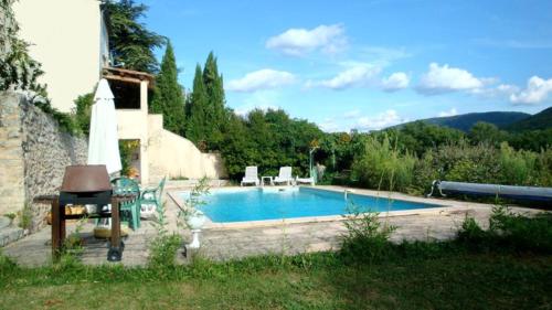 - une piscine avec une table et des chaises à côté d'une maison dans l'établissement Villa de 2 chambres avec piscine privee jardin clos et wifi a Dauphin, à Dauphin