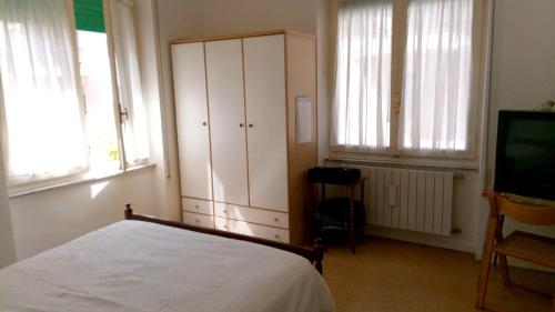 a bedroom with a bed and a tv and windows at Spacious Apartment in Pescara, 120 m², Ideal for Families in Pescara