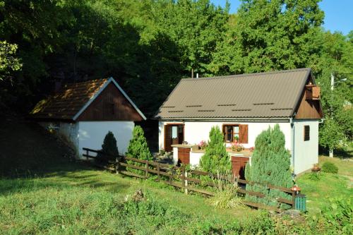 a small white house with a fence next to it at Cosy Chalet in Gospić with Jacuzzi and Mountain View in Gospić