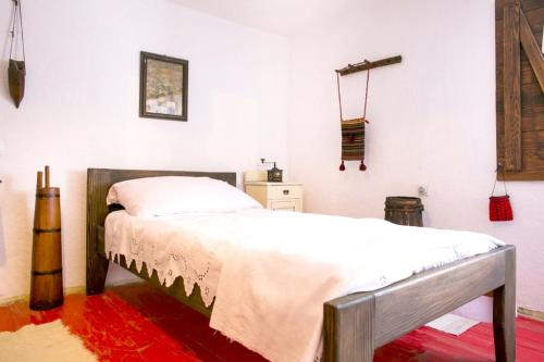 a bedroom with a bed and a red rug at Cosy Chalet in Gospić with Jacuzzi and Mountain View in Gospić