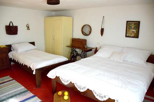 a bedroom with two beds with white sheets and a mirror at Cosy Chalet in Gospić with Jacuzzi and Mountain View in Gospić