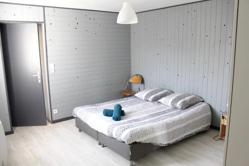 a bedroom with a bed with a blue teddy bear on it at Maison charmante à Saint-Patrice avec jardin privé in Saint-Patrice