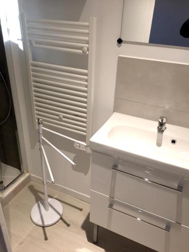 une salle de bain blanche avec un lavabo et un miroir dans l'établissement Villa charmante à Arpaillargues-et-Aureillac avec piscine privée, à Arpaillargues-et-Aureillac