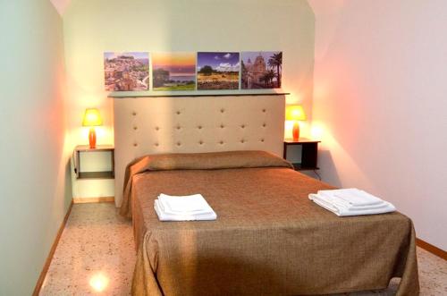 ラグーザにあるChic Apartment in Ragusa, 70m², Viewのベッドとタオル2枚のある寝室