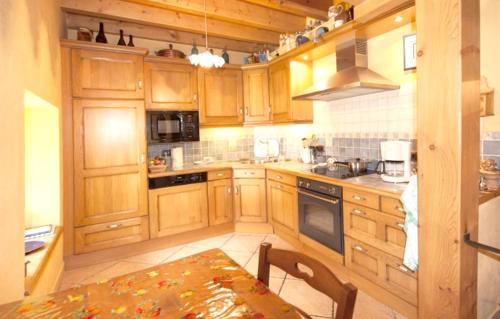 a kitchen with wooden cabinets and a table in it at Chalet chaleureux à Saint-André avec vue sur montagne in Saint-André