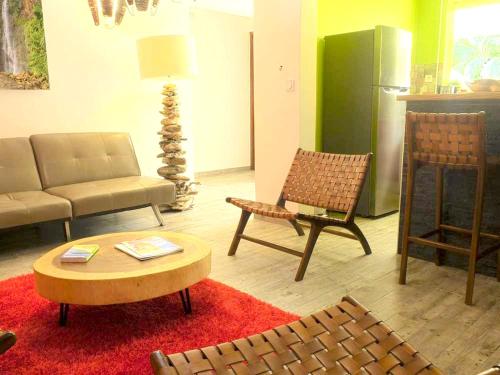 a living room with a couch and chairs and a table at Appartement spacieux avec jardin et piscine à Lamentin, 97 m² in Lamentin