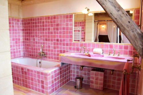 - une salle de bains carrelée de rose avec deux lavabos et une baignoire dans l'établissement Maison de 4 chambres avec piscine partagee et jardin amenage a Saint Cybranet, à Saint-Cybranet