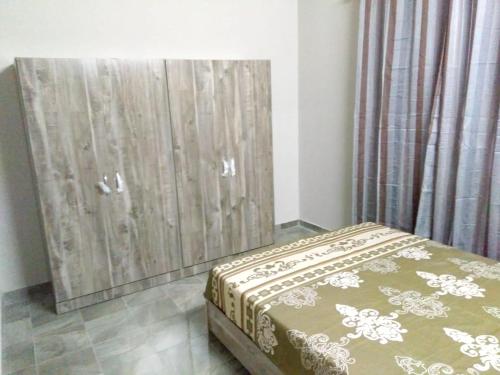 a bedroom with a bed and a wooden door at Charming House in Curepipe + Garden in Curepipe