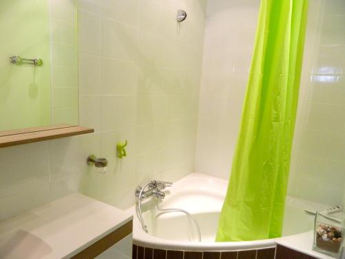 a bathroom with a shower with a green shower curtain at Maison familiale spacieuse à Le Verdon-sur-Mer avec jardin 120 m² in Le Verdon-sur-Mer