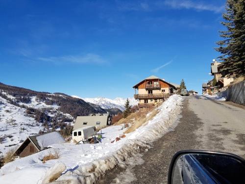 a car driving down a snowy road with a house at Appartement de 3 chambres avec balcon et wifi a Vars a 2 km des pistes in Vars