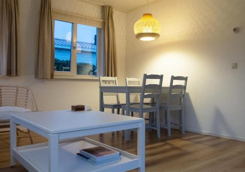 シント・アナラントにあるChaletparc Krabbenkreek Zeeland - Chalet 108のリビングルーム(白いテーブル、椅子付)