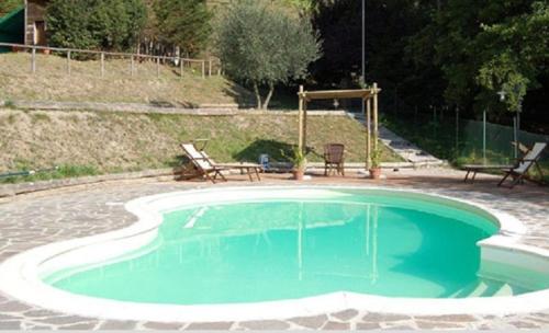 een klein zwembad met twee stoelen eromheen bij Agriturismo Spino Fiorito in Casola in Lunigiana