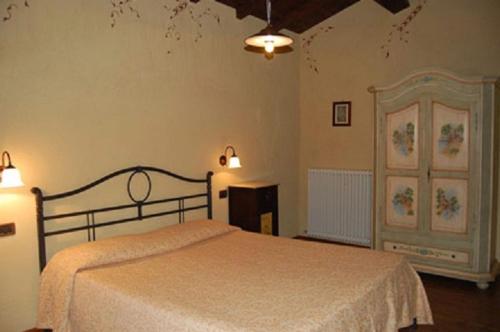 een slaapkamer met een bed met een witte sprei bij Agriturismo Spino Fiorito in Casola in Lunigiana