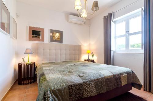una camera da letto con un letto grande e una finestra di Charming house in Vilamoura with shared pool a Vilamoura
