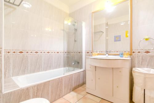 un bagno con lavandino, vasca e WC di Charming house in Vilamoura with shared pool a Vilamoura