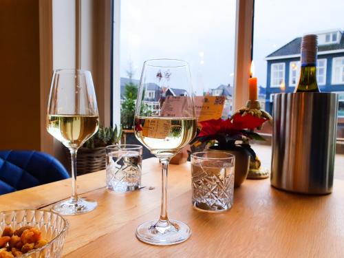 three glasses of white wine on a wooden table at Boutique Hotel Joure - centrum & haven in Joure