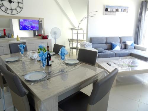 - une salle à manger avec une table, des chaises et un canapé dans l'établissement Appartement convivial à Berck avec vue sur mer (72m²) + Balcon, à Berck-sur-Mer