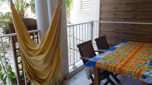 a balcony with a table and chairs on a porch at Maison d'une chambre avec piscine privee jacuzzi et jardin clos a Le Moule in Le Moule