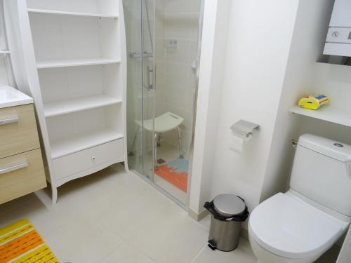 La salle de bains blanche est pourvue d'une douche et de toilettes. dans l'établissement Appartement de 2 chambres avec vue sur la mer et balcon amenage a Berck, à Berck-sur-Mer