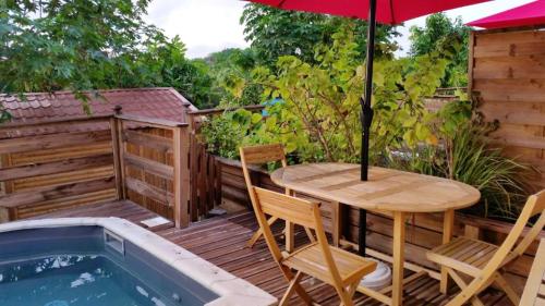 a patio with a table and chairs and an umbrella at Maison d'une chambre avec piscine privee jacuzzi et jardin clos a Le Moule in Le Moule