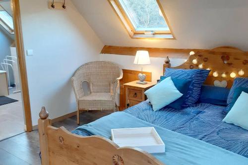 een slaapkamer met een bed met blauwe lakens en een raam bij Chalet de 3 chambres avec sauna et wifi a Arrens Marsous in Arrens-Marsous