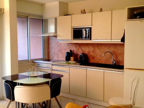 une petite cuisine avec une table et un micro-ondes dans l'établissement Appartement moderne à Fréjus - 39 m² - Vue sur mer, à Fréjus