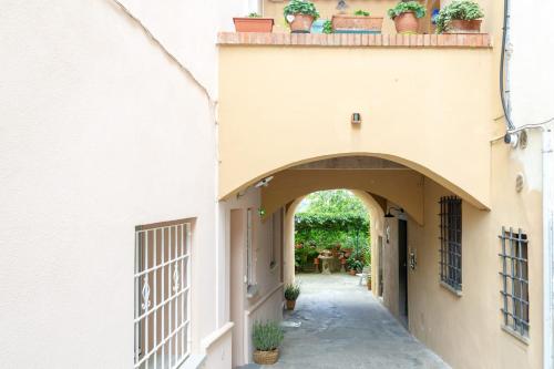 an alleyway between two buildings with potted plants on the roof at Refined Apartment in Lastra a Signa - 77 sqm - Air Conditioning in Lastra a Signa