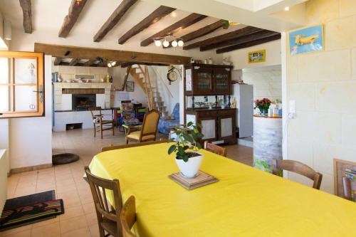 a dining room with a yellow table and a kitchen at Maison de 3 chambres avec jardin amenage et wifi a Ruille sur Loir in Ruillé-sur-Loir