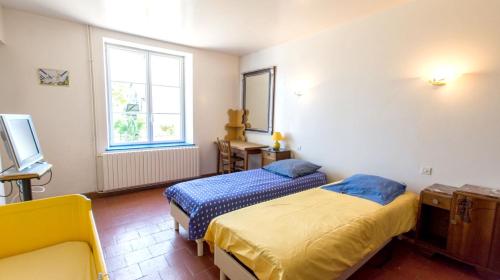 a bedroom with two beds and a tv and a window at Maison de 3 chambres avec jardin amenage et wifi a Ruille sur Loir in Ruillé-sur-Loir