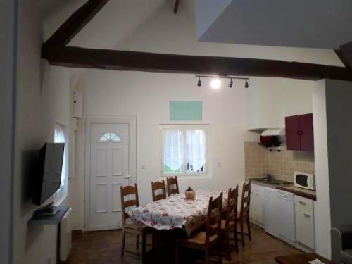 a kitchen with a table and chairs in a room at Maison de 3 chambres avec jardin clos et wifi a Edruchon in Saint-Martin-au-Bosc