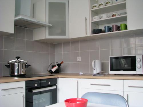 une cuisine avec des armoires blanches et un comptoir dans l'établissement Appartement cosy à Toulon avec vue sur la mer - 80 m², à Toulon