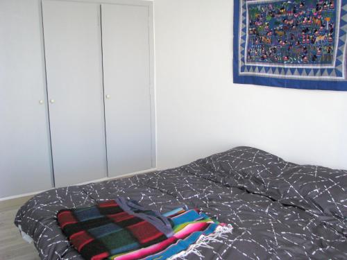 une chambre avec un lit avec une couverture dessus dans l'établissement Appartement cosy à Toulon avec vue sur la mer - 80 m², à Toulon