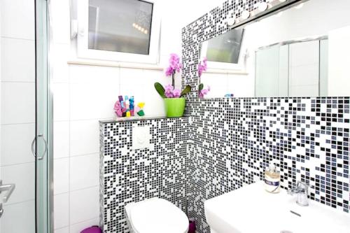 a bathroom with a black and white tiled wall at Modern Apartment in Trogir - 70 m² - Parking Included in Trogir