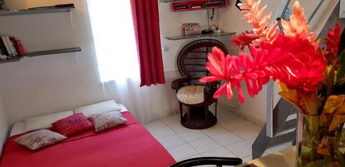 ein Zimmer mit einem Sofa und einer Vase mit roten Blumen in der Unterkunft Appartement d'une chambre avec jardin amenage et wifi a Lamentin in Lamentin
