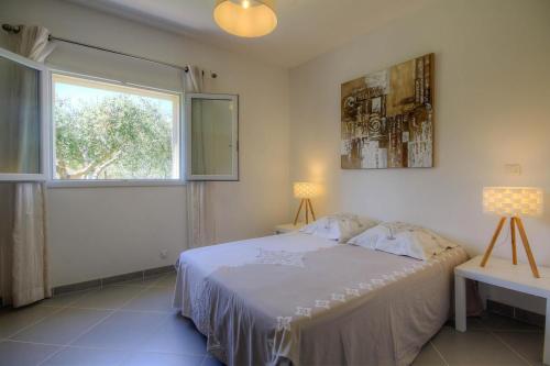 a bedroom with a white bed and a window at Appartement de 2 chambres avec jardin clos et wifi a Taglio Isolaccio in Taglio-Isolaccio