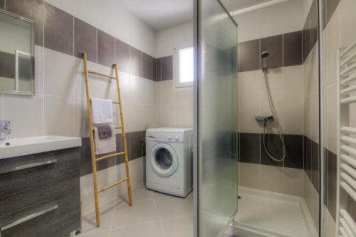 La salle de bains est pourvue d'un lave-linge et d'une douche. dans l'établissement Appartement moderne avec vue sur montagne à Taglio-Isolaccio, à Taglio-Isolaccio