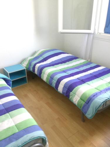 Cette chambre comprend deux lits installés à côté d'une fenêtre. dans l'établissement Maison charmante avec jardin, Saint-Hilaire-de-Riez, proche mer, à Saint-Hilaire-de-Riez