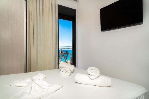 een kamer met een witte tafel met handdoeken en een raam bij Atoli Studios in Skala Marion