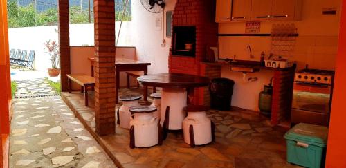 a small kitchen with a table and a stove at VILLA GARDEN - Suites in Maresias