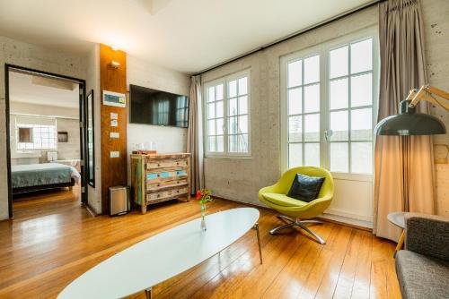 a living room with a table and a yellow chair at Palla Boutique Hotel in Arequipa