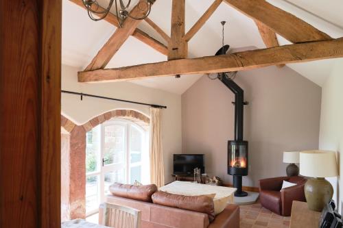 a living room with a couch and a window at Swallow Barn at Millfields Farm Cottages in Ashbourne