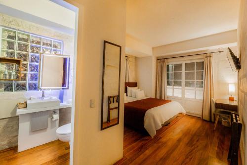 a bedroom with a bed and a bathroom with a sink at Palla Boutique Hotel in Arequipa