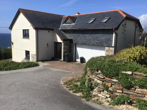a white house with a black roof and a driveway at Captivating 8-Bed House in Porthleven in Porthleven