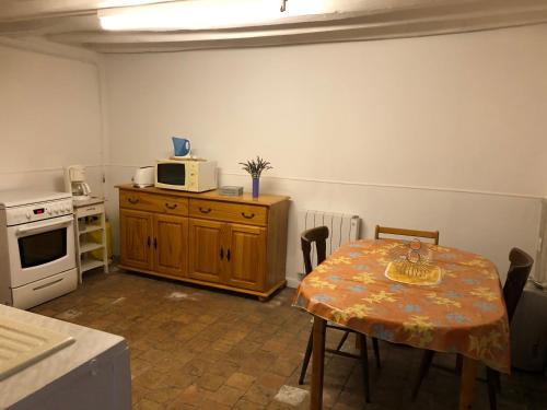 eine kleine Küche mit einem Tisch und einer Mikrowelle in der Unterkunft Maison typique de sologne in La Chapelle-dʼAngillon